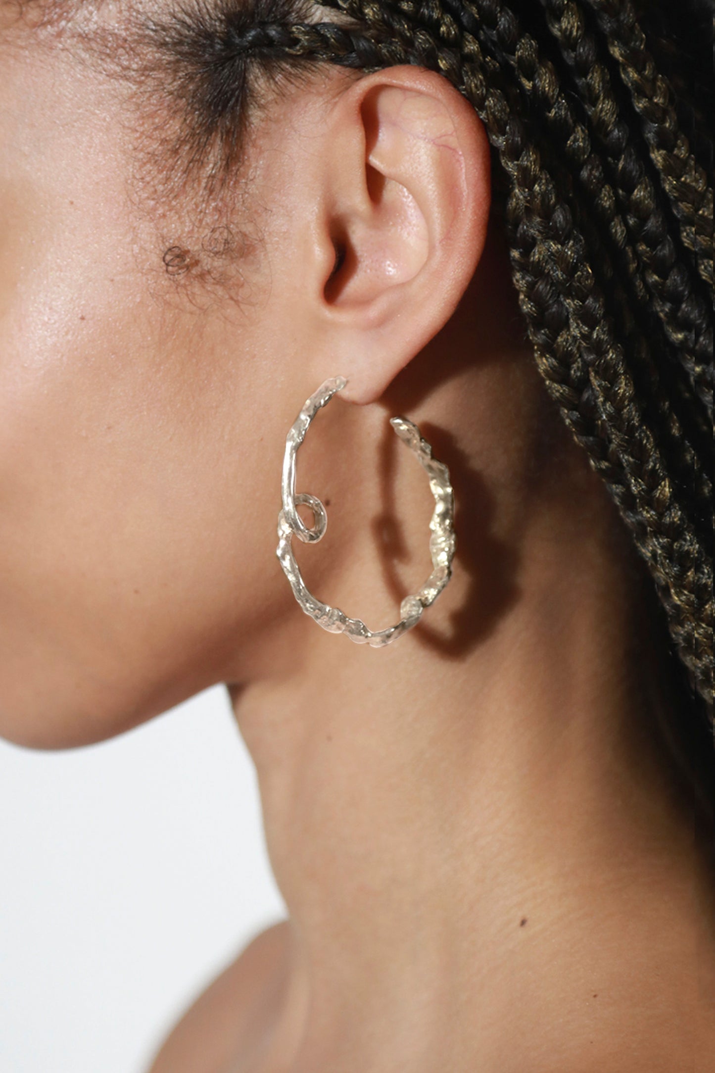 Detail shot of Medusa Curl Hoops in Sterling Silver. These luxury earrings are made out of high quality metal and are a perfect gift for any special occasion.