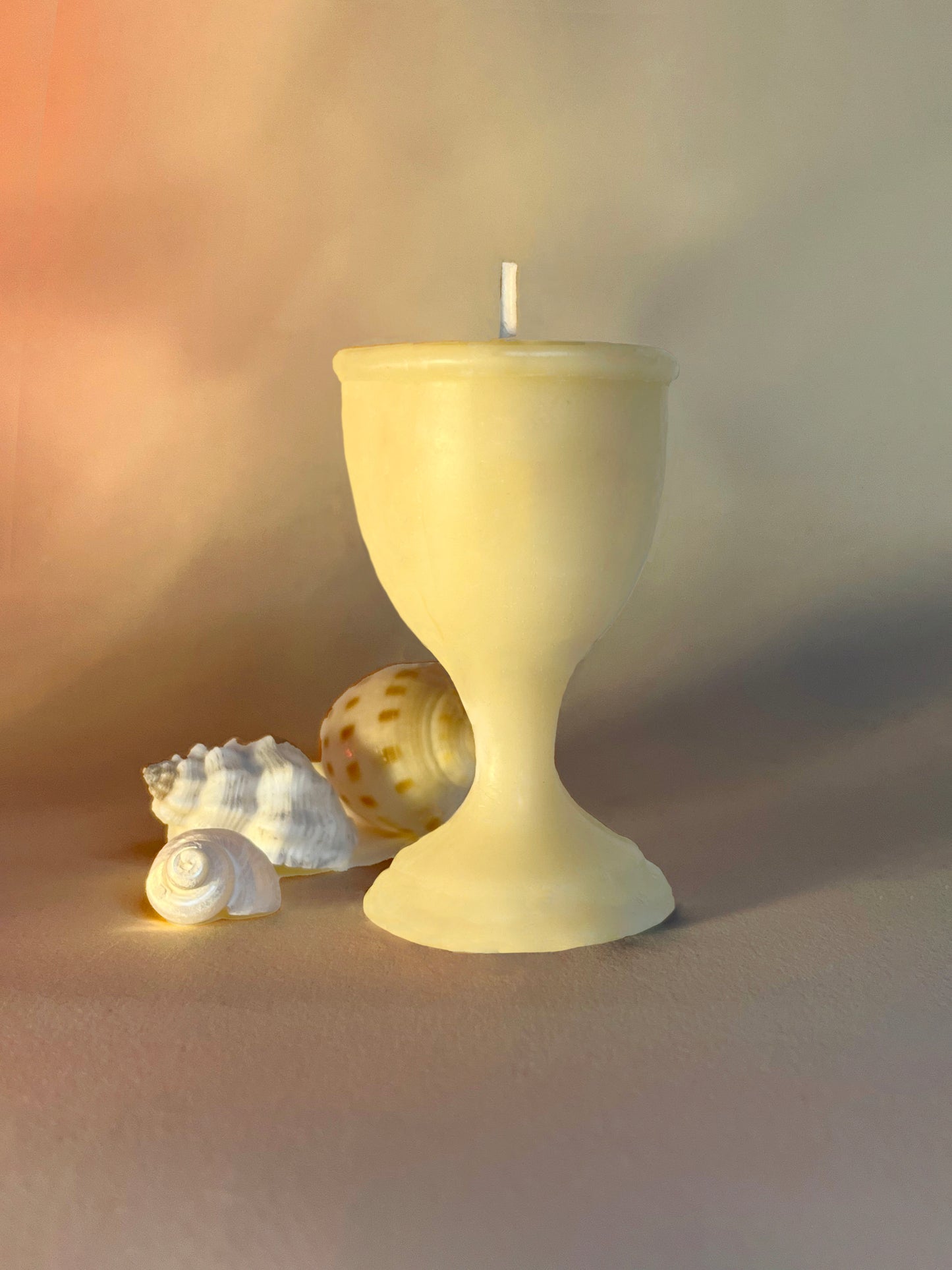 A 100% Beeswax hand-poured candle in the shape of a cup. This candle is eco-friendly and artisanal.