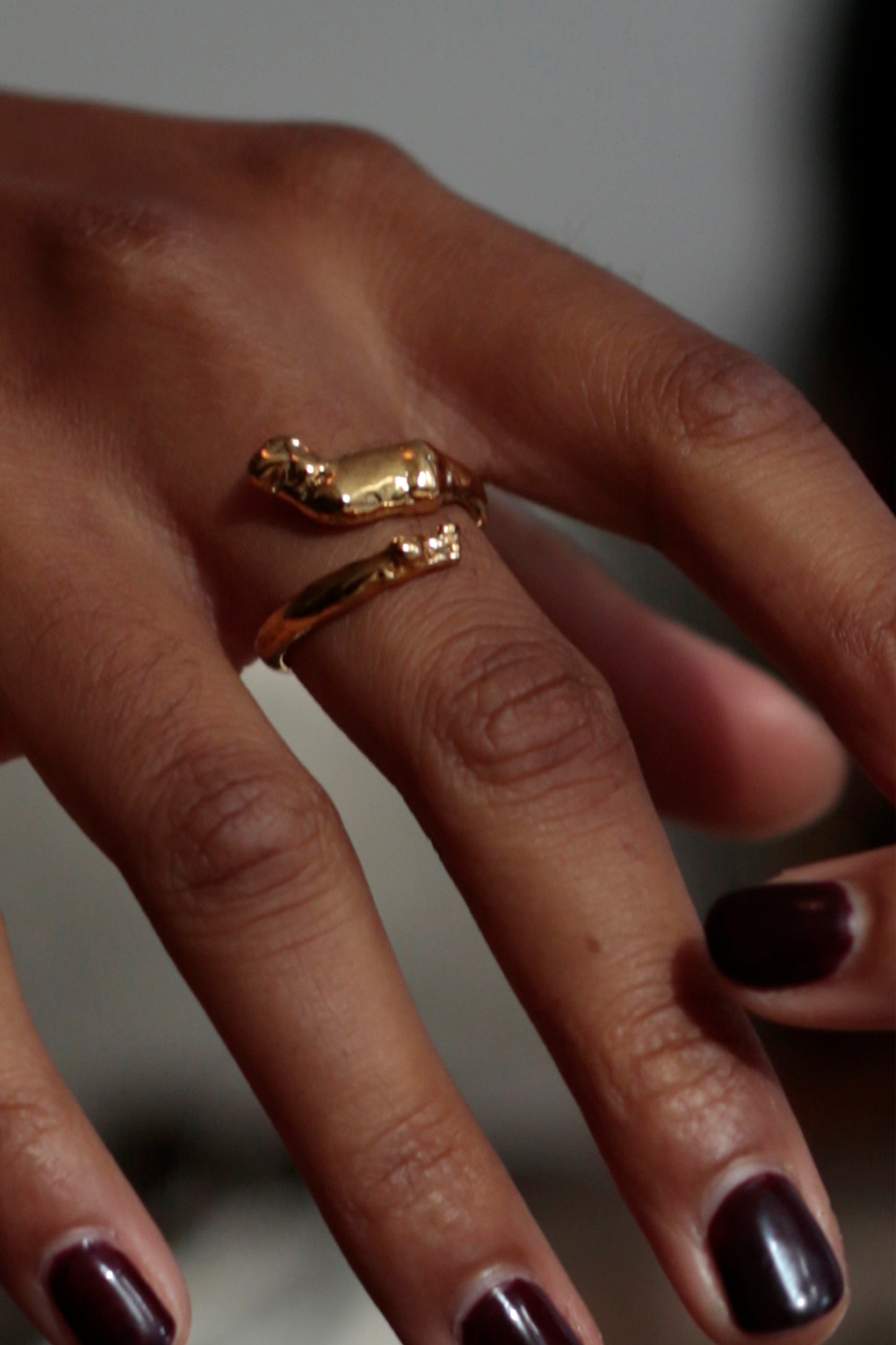 Model wearing Cupid Ring by CLARK in 18K Gold Vermeil on her middle finger. The ring is adjustable and wrapped around the finger with ease. This romantic ring is a perfect gift for an anniversary or wedding.