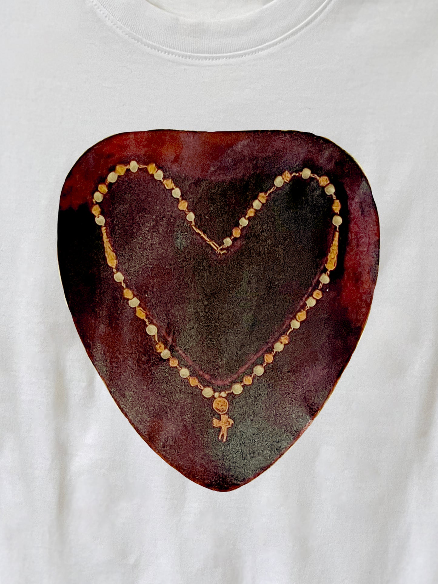 Close up of whimsical design - a photo collage of a necklace with an angel charm in the shape of a heart on a red ground. This shirt is white. A perfect gift for someone who loves to mix renaissance atheistic and streetwear.