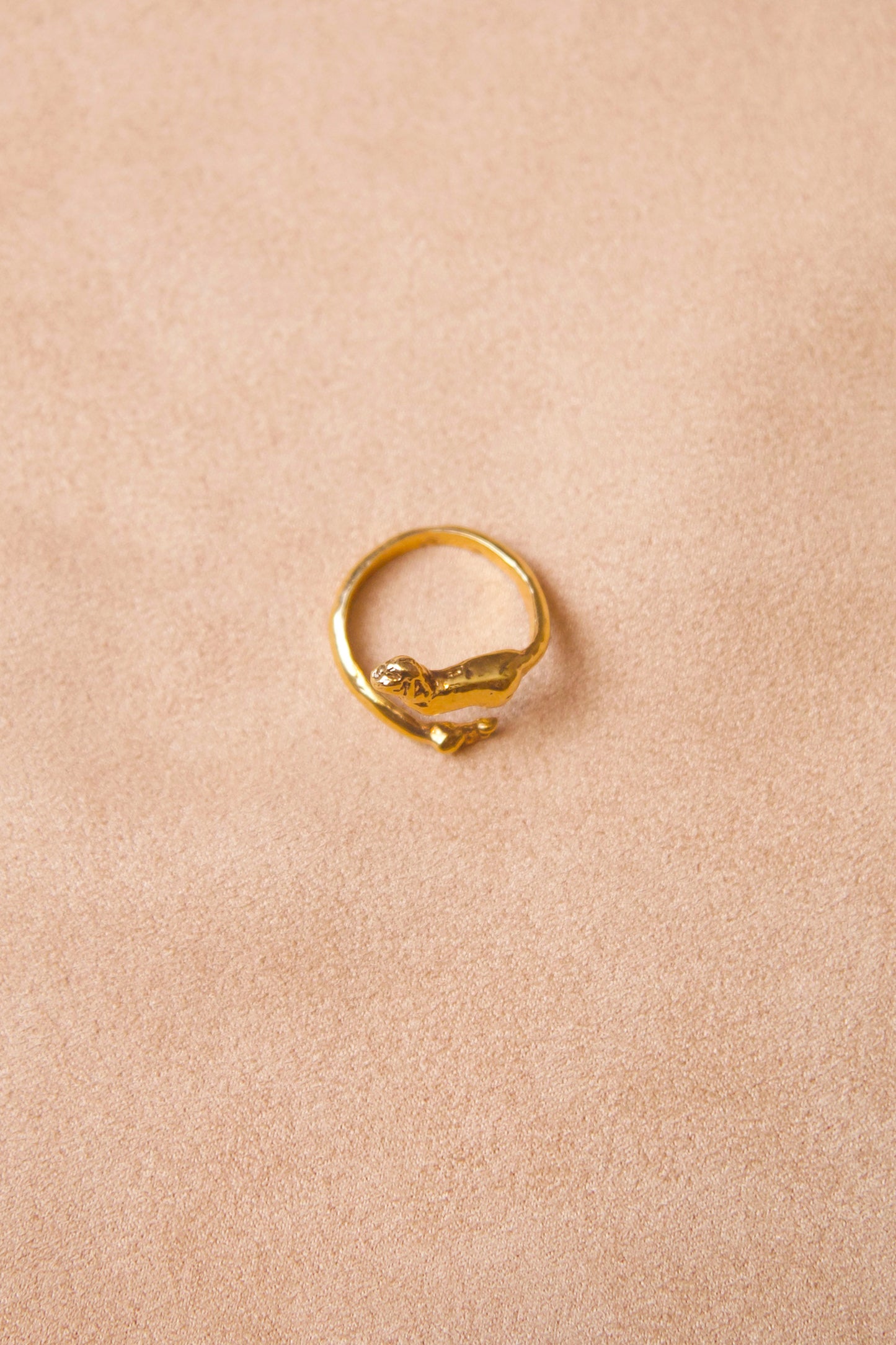 Top view of 18K Gold Vermeil Cupid Ring by CLARK. Gold band is a cheeky personification of cupid. The top, a wing in flight with a little butt and the bottom a small foot. Flexible band allows for the ring to be adjustable.