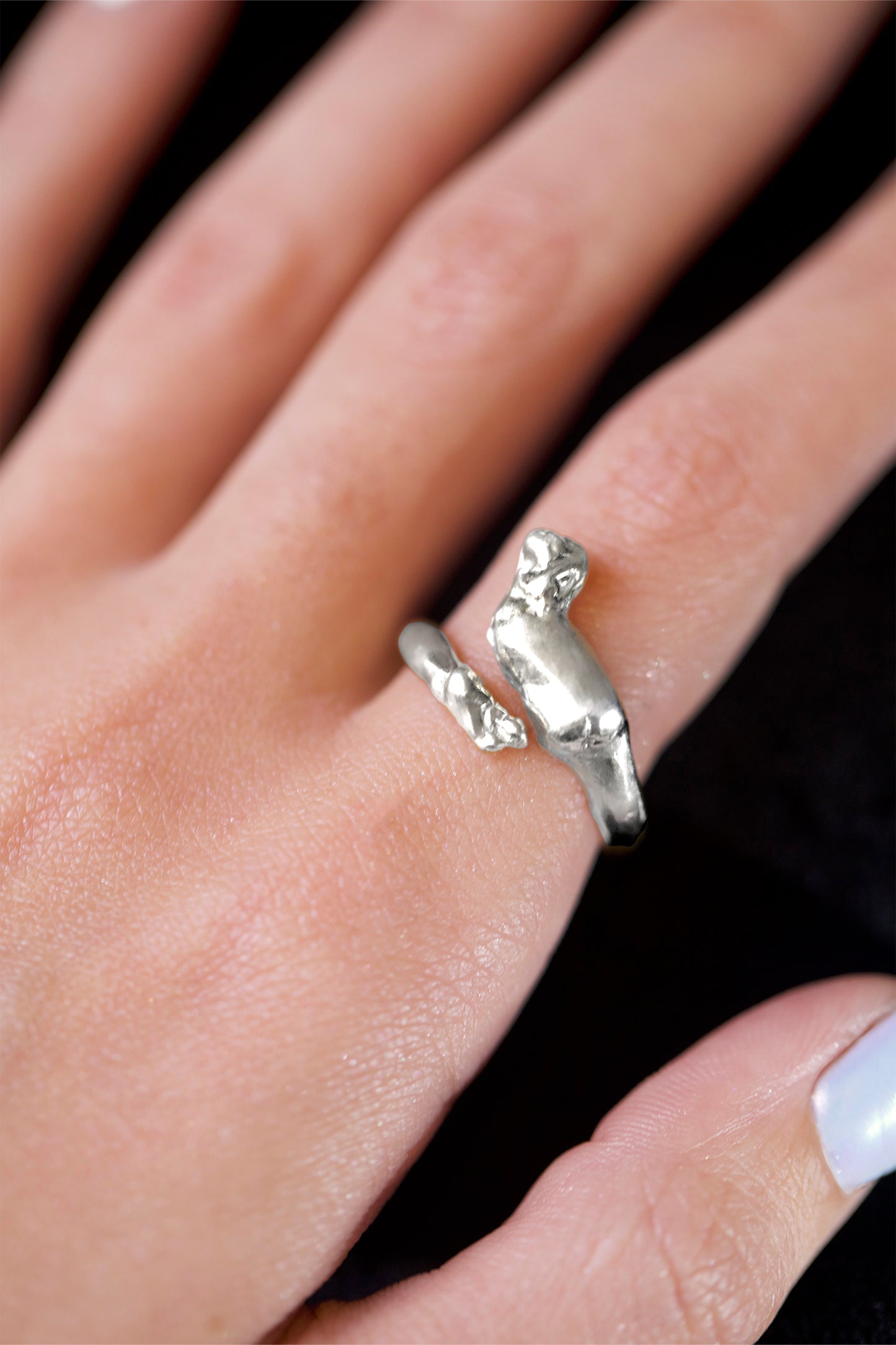 Detailed view of Sterling Silver Cupid Ring by CLARK. The hand craft and romantic details of the wing and foot are clearly in view. This is a unique statement adjustable ring.