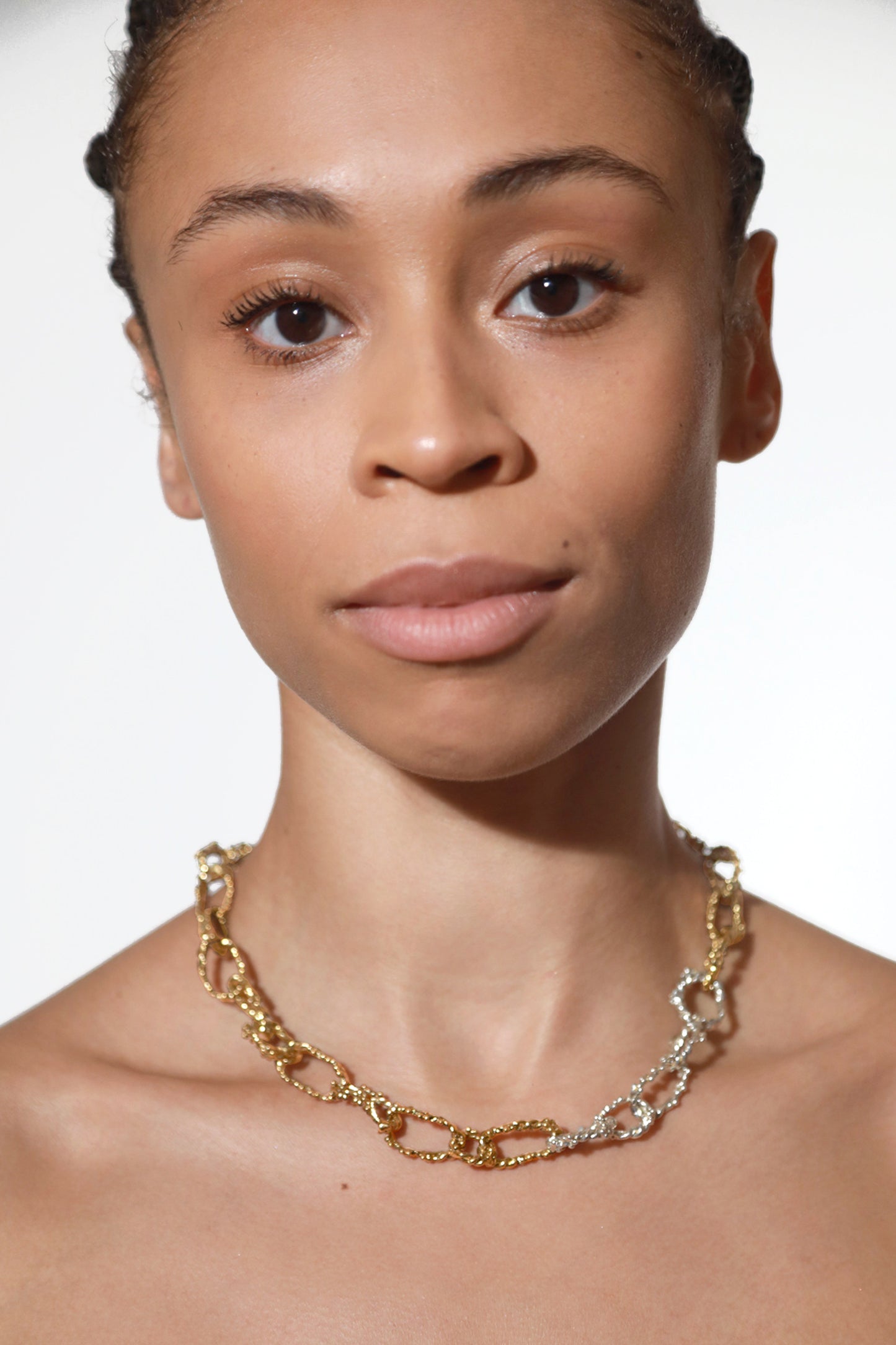 Model wears CLARK necklace. Flower links connected to form a choker chain necklace, exuding a unique mixed metal piece. A perfect one-of-a-kind gift.