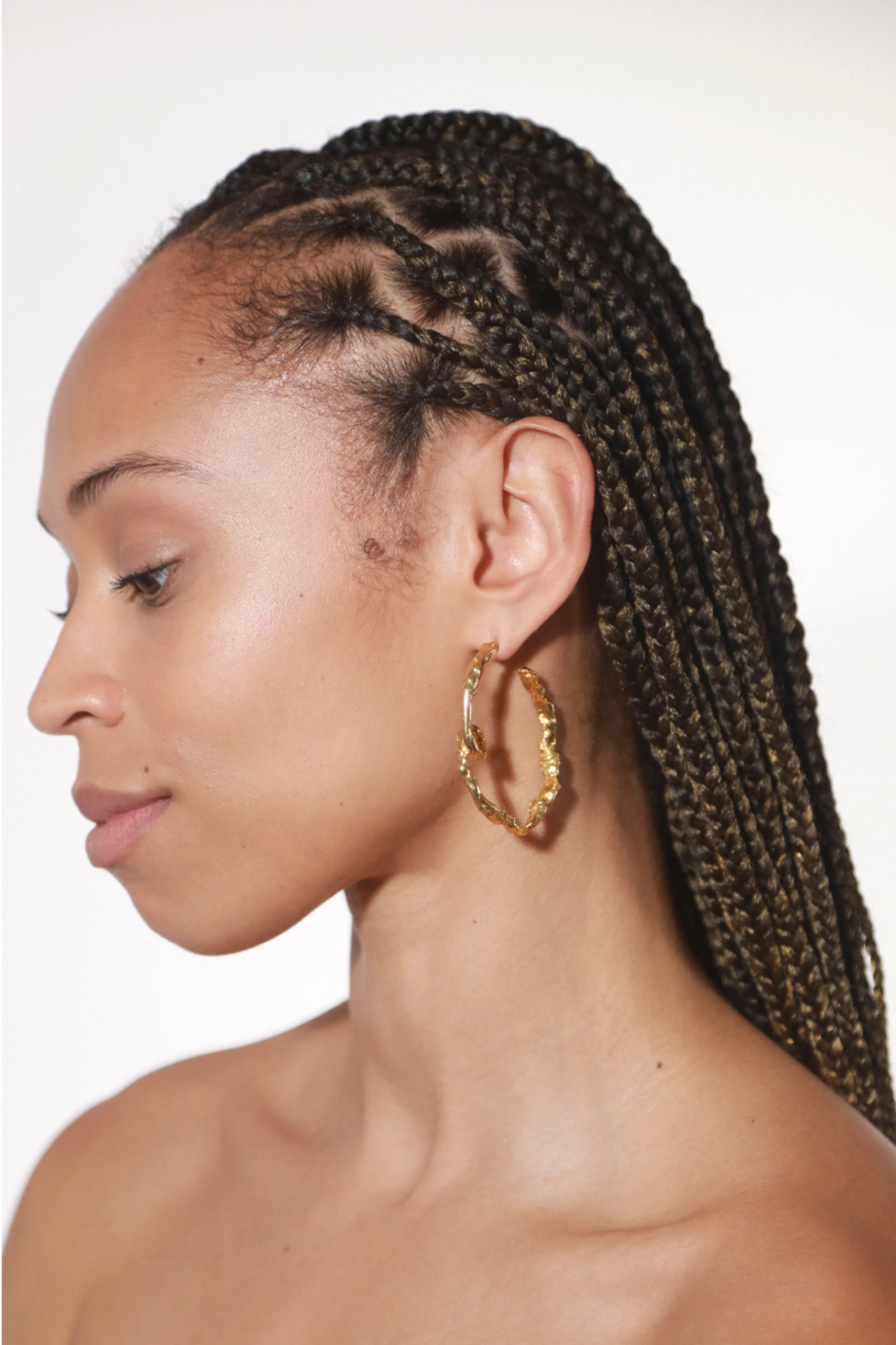 Photo of model wearing CLARK Medusa Curl Hoop earrings in 18k Gold Vermeil. These sculptural one-of-a-kind hoops show off the unique loop on bottom of statement hoops. 