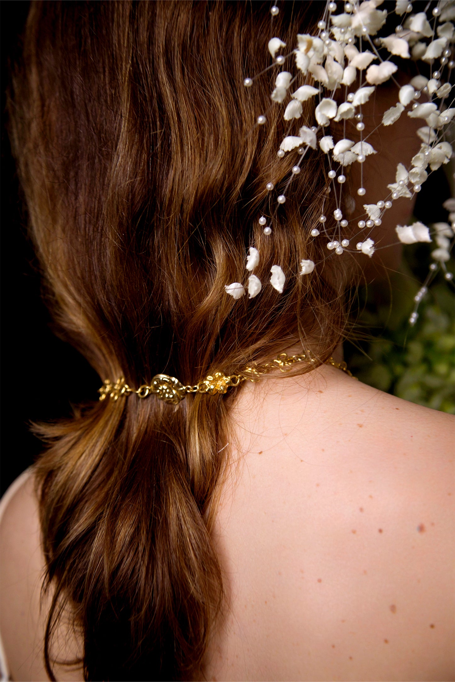 Back view of the Earthly Delight Necklace by CLARK in 18K Gold Vermeil, the linked flowers and hand-pressed coins are a romantic detail for this special occasion. 