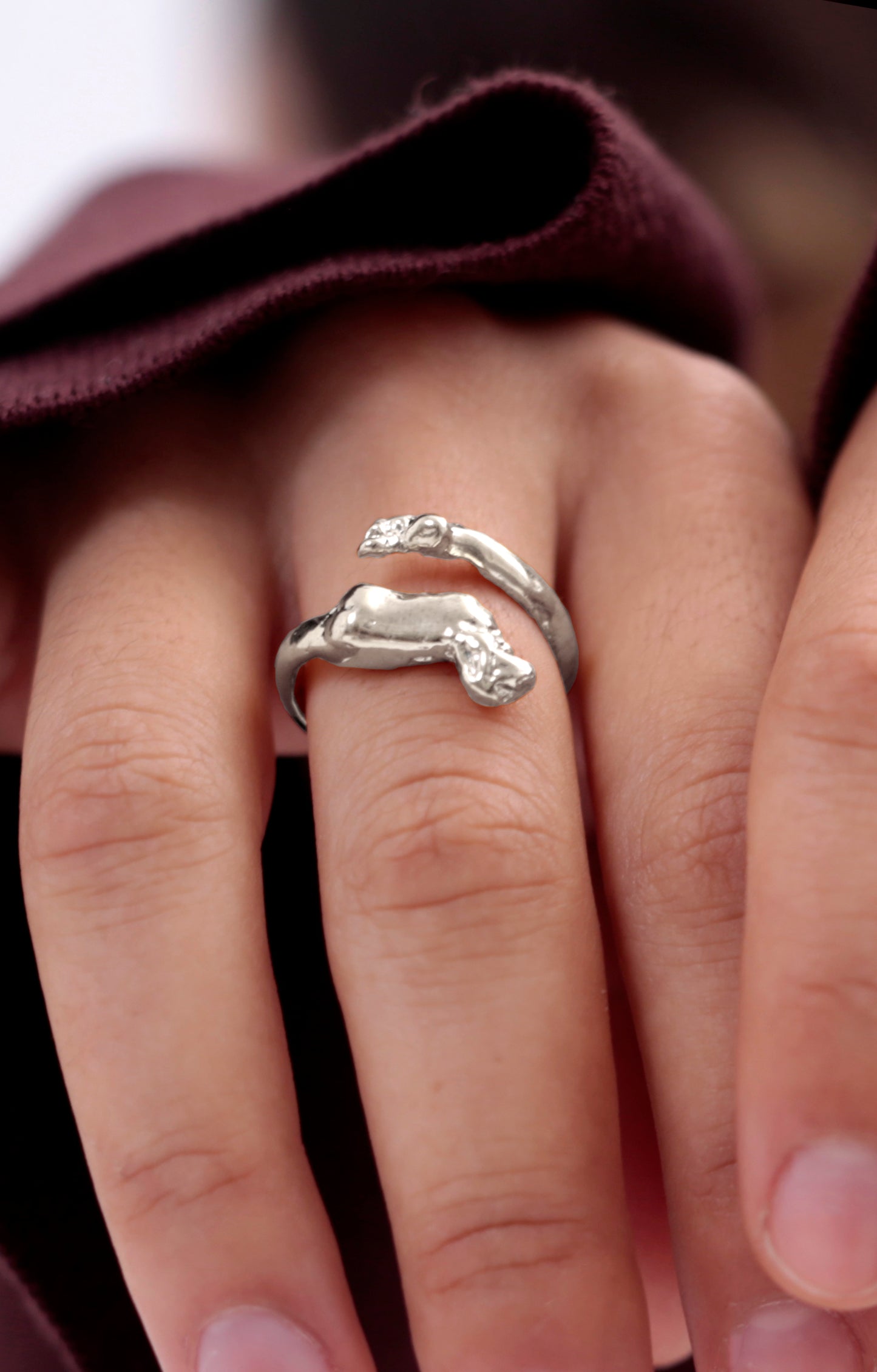 Detailed view of Sterling Silver Cupid Ring by CLARK. The hand craft and romantic details of the wing and foot are clearly in view. This is a unique statement adjustable ring.