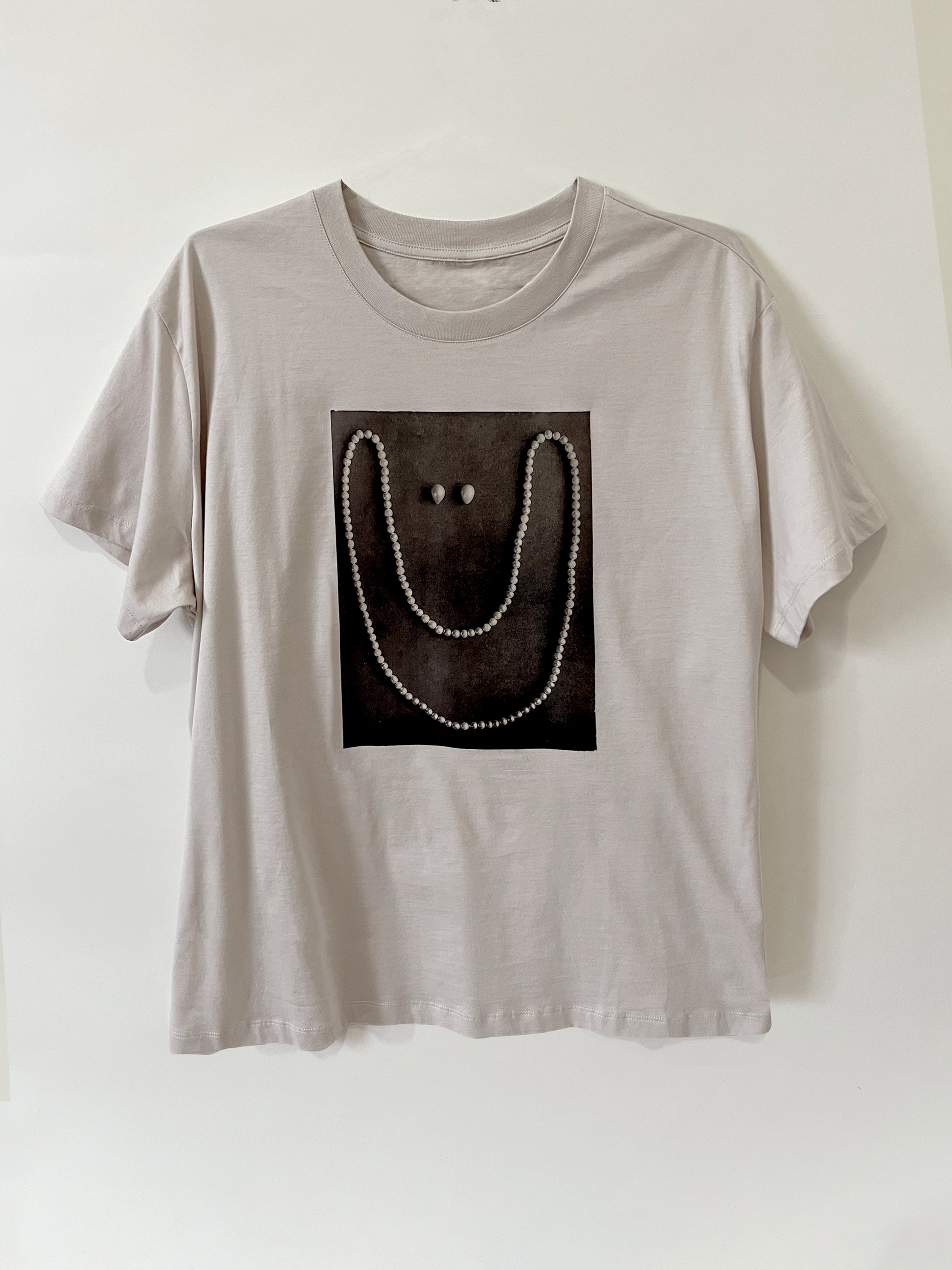 Product photo of Happy As A Clam tee by CLARK. A graphic custom-made gray straight-cut shirt featuring a smile made out of pearls. It is an artist made to order item, available in s/m and l/xl.