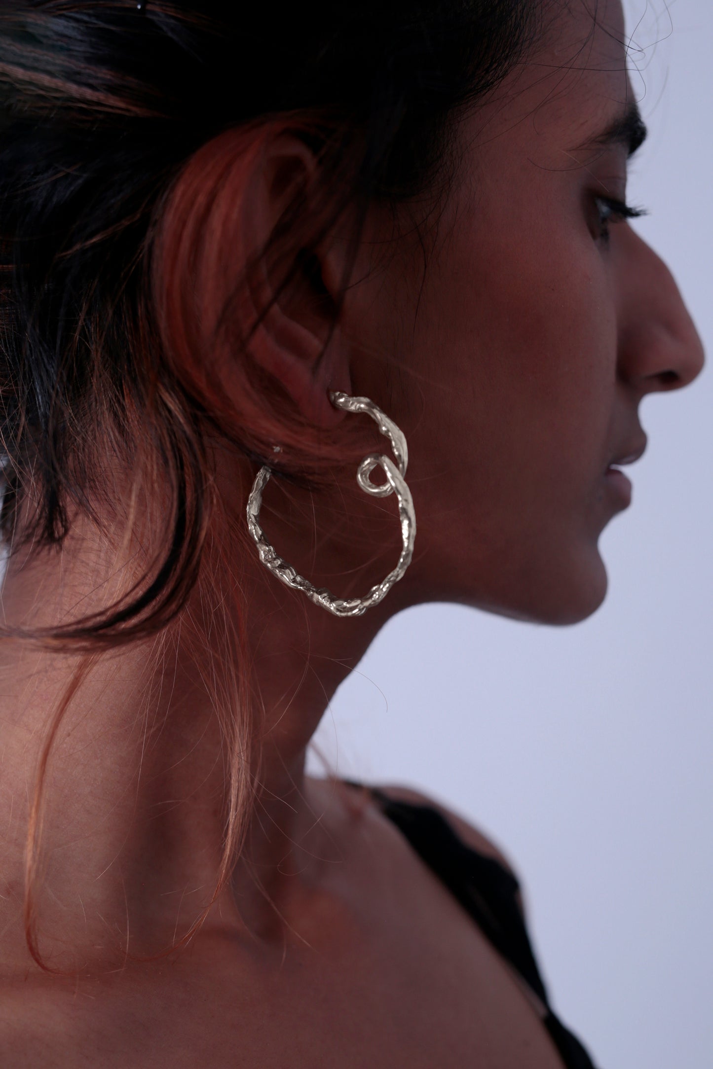 Side view of CLARK Medusa Curl Earrings in a high-polish Sterling Silver. These luxury earrings are made out of high quality metal and are a perfect gift for any special occasion. 