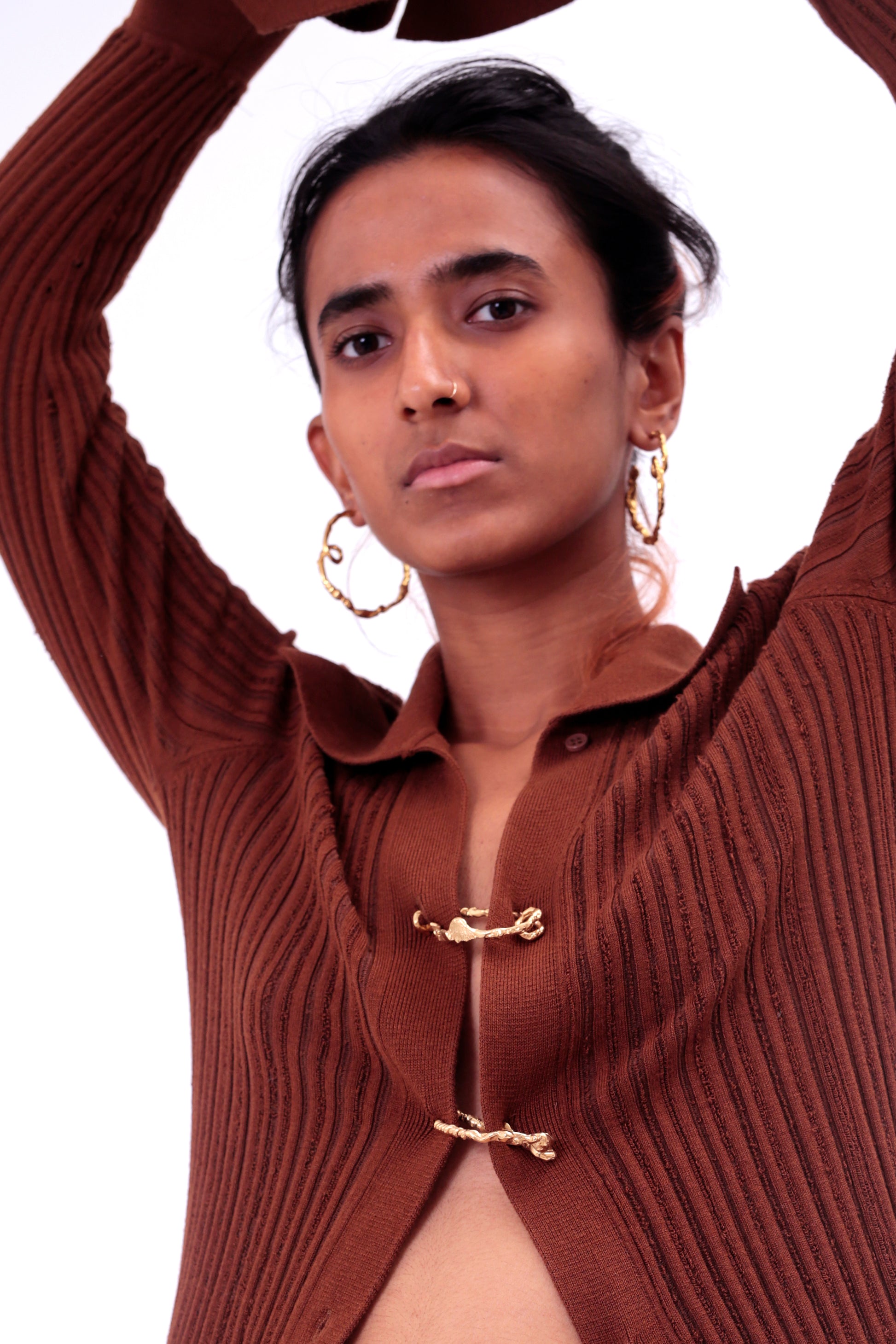 Photo of model wearing CLARK Medusa Curl Hoop earrings in 18k Gold Vermeil. These sculptural one-of-a-kind hoops show off the unique loop on bottom of statement hoops. 