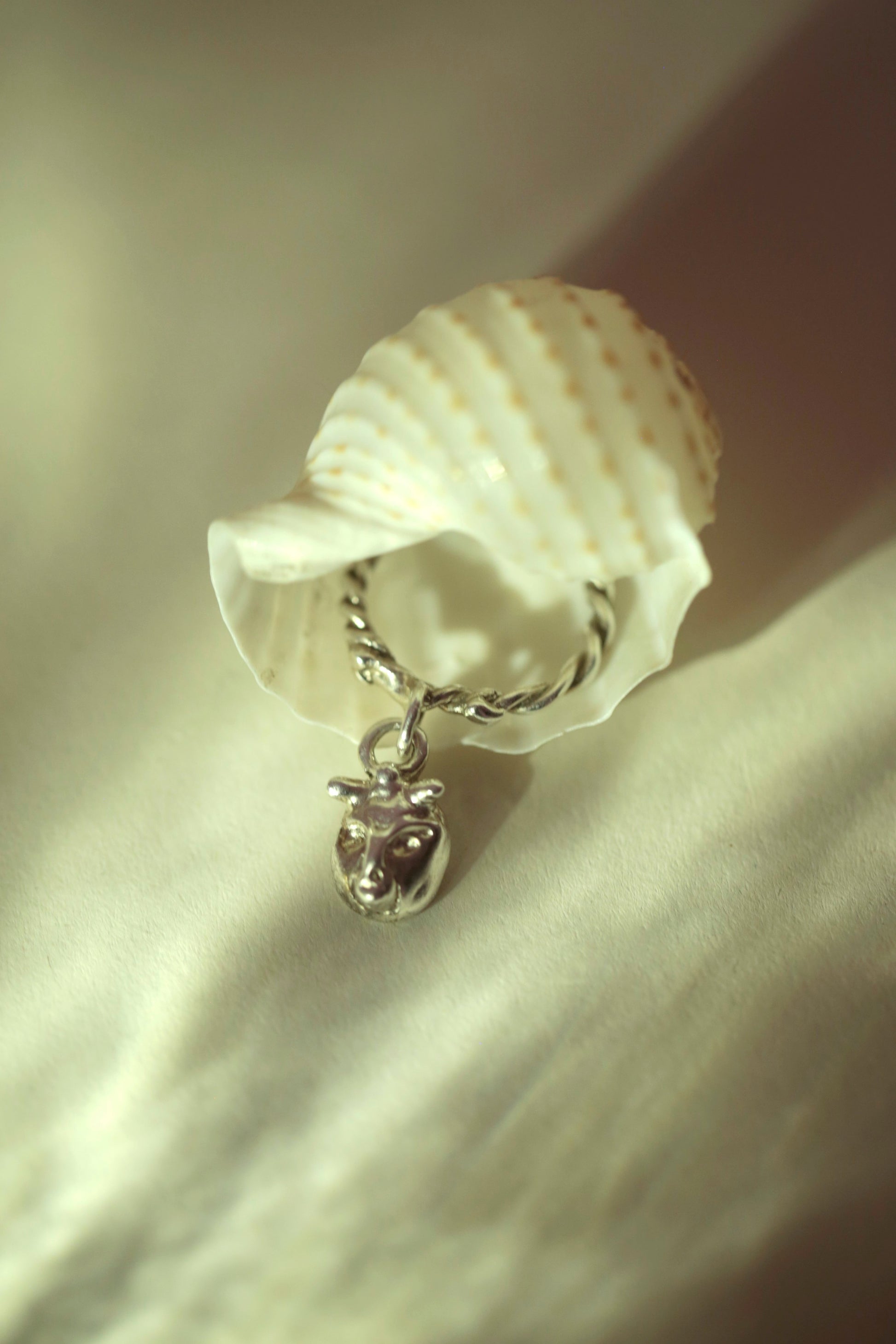 Lilith Charm Ring by CLARK in Sterling Silver. Ring is peeking out of a seashell with dappled light. This is a unique, one-of-a-kind statement ring. Handcrafted using the lost-wax-casting method.