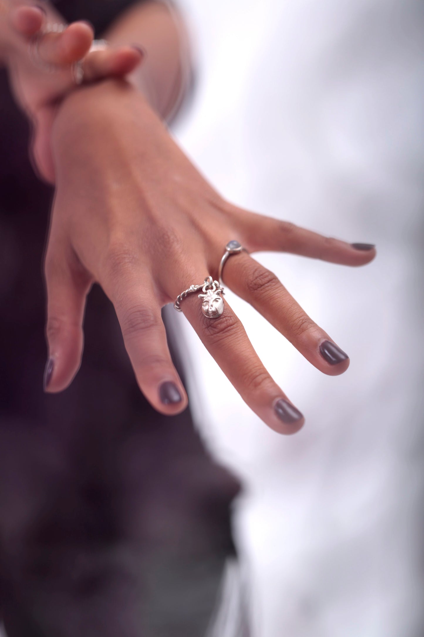 Model wears a Lilith Charm Ring by CLARK on her index finger. Model is also wearing a Magic Moonstone ring by CLARK. Both rings are cast and polished in Sterling Silver. 