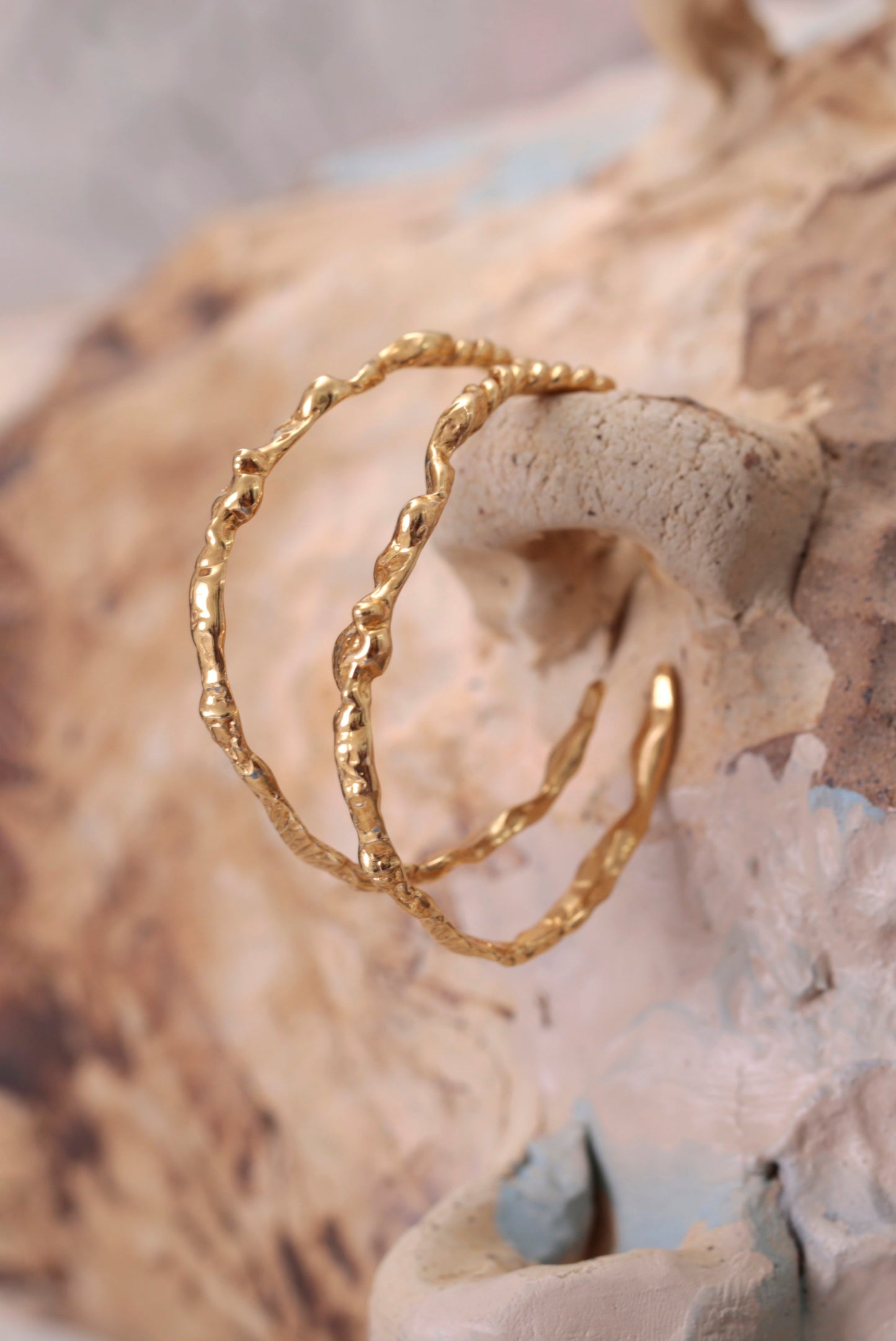 18K Gold Vermeil CLARK Sea Siren Hoops hooked into organic ceramic pot. Bold sculptural hoops with seafloor textures. A luxury statement gift. 