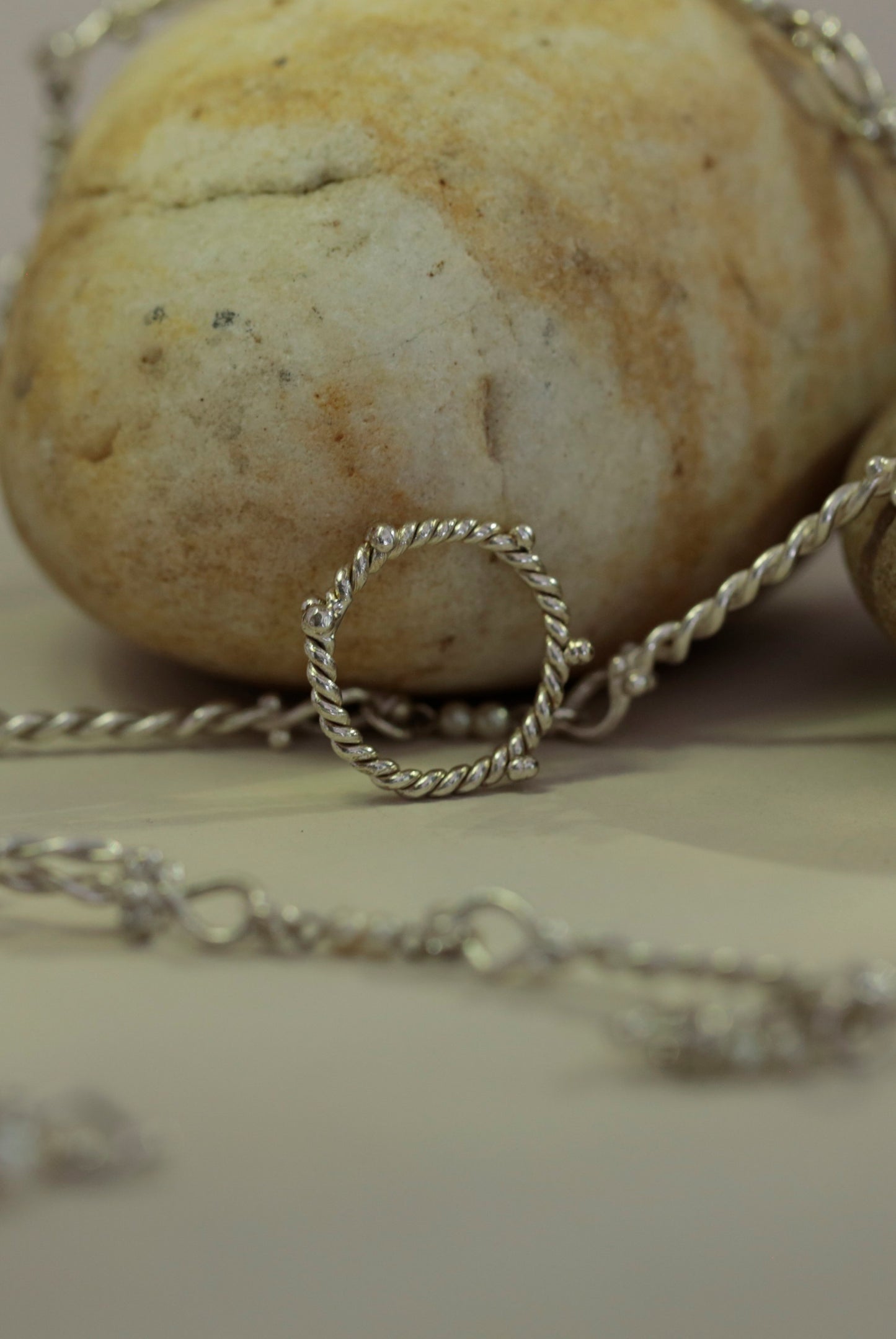 Sterling Silver Twisted Starboard Ring by CLARK resting against nautical background. This one-of-a-kind handmade twisted band was made by an artist in Brooklyn and completely unique.